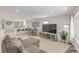 Open concept living room with kitchen view, sleek furniture, and hardwood style flooring at 7752 Meade St, Westminster, CO 80030