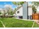 Backyard featuring a well-maintained lawn, patio, and a home exterior with brick accents at 4643 S Vrain St, Denver, CO 80236