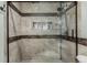 Beautiful, tiled shower with glass door and useful in-set shelving at 4643 S Vrain St, Denver, CO 80236