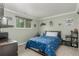 Comfortable bedroom with blue bedspread, window for natural light, and display shelves at 4643 S Vrain St, Denver, CO 80236