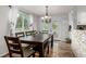Bright dining area with a large wood table, chandelier, and access to the outdoor patio at 4643 S Vrain St, Denver, CO 80236