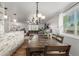 Open concept dining area with view to living room, a large wood table, and decorative lighting at 4643 S Vrain St, Denver, CO 80236