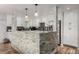Modern kitchen with white cabinets, stone backsplash, stainless steel appliances, and stylish lighting at 4643 S Vrain St, Denver, CO 80236
