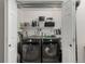 Well-organized laundry room with modern washer and dryer, shelving and open storage at 4643 S Vrain St, Denver, CO 80236