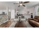 Open living room with hardwood floors, chairs, decorative stone wall, and staircase visible at 4643 S Vrain St, Denver, CO 80236