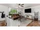 Comfortable living room with a brown leather sofa, ceiling fan, large window, and stylish decor at 4643 S Vrain St, Denver, CO 80236