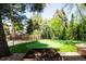 Backyard with a putting green, surrounding trees, and a fenced perimeter at 3355 E Eastman Ave, Denver, CO 80210