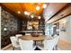 Chic dining area featuring stylish wallpaper, a modern light fixture, and seamless access to the bar and outdoor area at 3355 E Eastman Ave, Denver, CO 80210