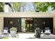 Stylish home entrance with black-framed glass doors, wood-paneled walls, and decorative planters with flower accents at 3355 E Eastman Ave, Denver, CO 80210