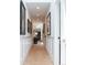 Hallway with clean white walls, wood floors, and artwork, creating a bright and airy passage at 3355 E Eastman Ave, Denver, CO 80210