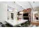 Bright kitchen with a marble island, pendant lighting, stainless appliances, and exposed brick at 3355 E Eastman Ave, Denver, CO 80210