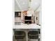 Kitchen island with marble countertop and seating, a brick fireplace, and modern appliances at 3355 E Eastman Ave, Denver, CO 80210