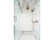 Close-up of shower with glass surround, and brushed gold rain shower and shower head, with seating at 3355 E Eastman Ave, Denver, CO 80210