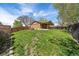 Expansive backyard with mature trees, green lawn, and a charming covered patio area at 8364 Allison Ct, Arvada, CO 80005