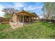 A well-maintained backyard with lush green grass, a covered patio, and privacy fencing at 8364 Allison Ct, Arvada, CO 80005