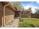 Charming brick home with an inviting front entrance, landscaped garden beds, and an American flag at 8364 Allison Ct, Arvada, CO 80005