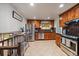 A kitchen featuring stainless steel appliances and wood cabinetry with tiled flooring at 8364 Allison Ct, Arvada, CO 80005