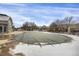 Community pool featuring a protective cover, with snow on the pool deck and a clubhouse in the background at 3601 E 103Rd Cir # B11, Thornton, CO 80229