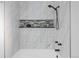 Bathroom featuring marble-style tiling, a shower-tub, and modern fixtures at 12780 Elm St, Thornton, CO 80241
