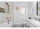 Modern bathroom with white marble-style tiling, a shower-tub, and sleek fixtures at 12780 Elm St, Thornton, CO 80241
