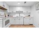 Clean, all-white kitchen with modern appliances, ample counter space, and a functional layout at 12780 Elm St, Thornton, CO 80241
