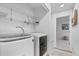Modern laundry room with shelving, and white washer and dryer units at 12780 Elm St, Thornton, CO 80241