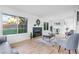Cozy living room with fireplace, modern furniture, and ample natural light from large windows overlooking the backyard at 12780 Elm St, Thornton, CO 80241