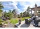 Outdoor living space showcasing a stone water feature, covered patio, and lush landscaping at 23742 E Calhoun Ave, Aurora, CO 80016