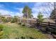 Serene backyard featuring a wooden fence, lush lawn, mature trees, and thoughtful landscaping at 23742 E Calhoun Ave, Aurora, CO 80016