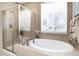 Bathroom showcasing a glass enclosed shower, soaking tub and tile floor at 23742 E Calhoun Ave, Aurora, CO 80016