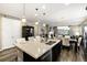 Kitchen island boasts stone countertops, a breakfast bar, stainless sink and faucet, and pendant lighting at 23742 E Calhoun Ave, Aurora, CO 80016