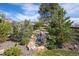 Relaxing backyard stone waterfall feature surrounded by lush greenery and mature trees at 23742 E Calhoun Ave, Aurora, CO 80016