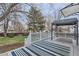 Landscaped backyard view featuring a covered deck with outdoor rug and white railings at 9902 Independence St, Broomfield, CO 80021
