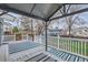 Inviting covered back deck with blue-striped outdoor rug and white railing overlooking backyard at 9902 Independence St, Broomfield, CO 80021