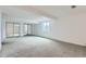Expansive carpeted basement space with mirrored closet doors and a window for natural light at 9902 Independence St, Broomfield, CO 80021