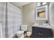 Cozy bathroom featuring a shower with patterned curtain, white vanity and framed mirror at 9902 Independence St, Broomfield, CO 80021