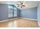 Bedroom with vaulted ceiling, large windows, ceiling fan, and wood laminate flooring at 9902 Independence St, Broomfield, CO 80021