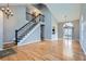Spacious living area showcasing a staircase with black railings, hardwood floors, and a modern chandelier at 9902 Independence St, Broomfield, CO 80021