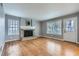 Cozy living room featuring a brick fireplace, hardwood floors, and large windows for natural light at 9902 Independence St, Broomfield, CO 80021