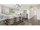 Bright bedroom features a large bed, ceiling fan, soft rug, dresser and natural lighting at 3745 Balderas St, Brighton, CO 80601
