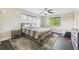 Well-lit bedroom features a ceiling fan, large bed, soft rug, and multiple windows at 3745 Balderas St, Brighton, CO 80601