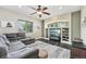 Inviting living room featuring a large sectional sofa, a ceiling fan, and built-in shelving at 3745 Balderas St, Brighton, CO 80601