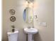 Powder room featuring pedestal sink, decorative mirror, and neutral color scheme at 3309 Thornwood Ct, Castle Rock, CO 80108