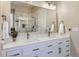 Bright bathroom featuring a dual vanity, tile backsplash, and large mirror at 3309 Thornwood Ct, Castle Rock, CO 80108