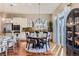 Well-lit dining area with a table, a modern light fixture, and a view into the kitchen through a sliding glass door at 3309 Thornwood Ct, Castle Rock, CO 80108