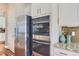 Modern kitchen appliances including stainless steel refrigerator and double ovens, set against a stylish backsplash at 3309 Thornwood Ct, Castle Rock, CO 80108