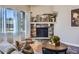 Cozy living room with a stone fireplace, large window with natural light, and stylish decor at 3309 Thornwood Ct, Castle Rock, CO 80108