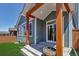 Back porch view showing wood post supports, covered patio, sliding glass door, and manicured yard at 11494 Colony Loop, Parker, CO 80138