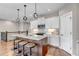 Bright kitchen featuring a large island with stool seating, modern light fixtures and stainless steel appliances at 11494 Colony Loop, Parker, CO 80138