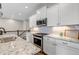 Modern kitchen featuring granite countertops, stainless steel appliances, white cabinets, and tile backsplash at 11494 Colony Loop, Parker, CO 80138